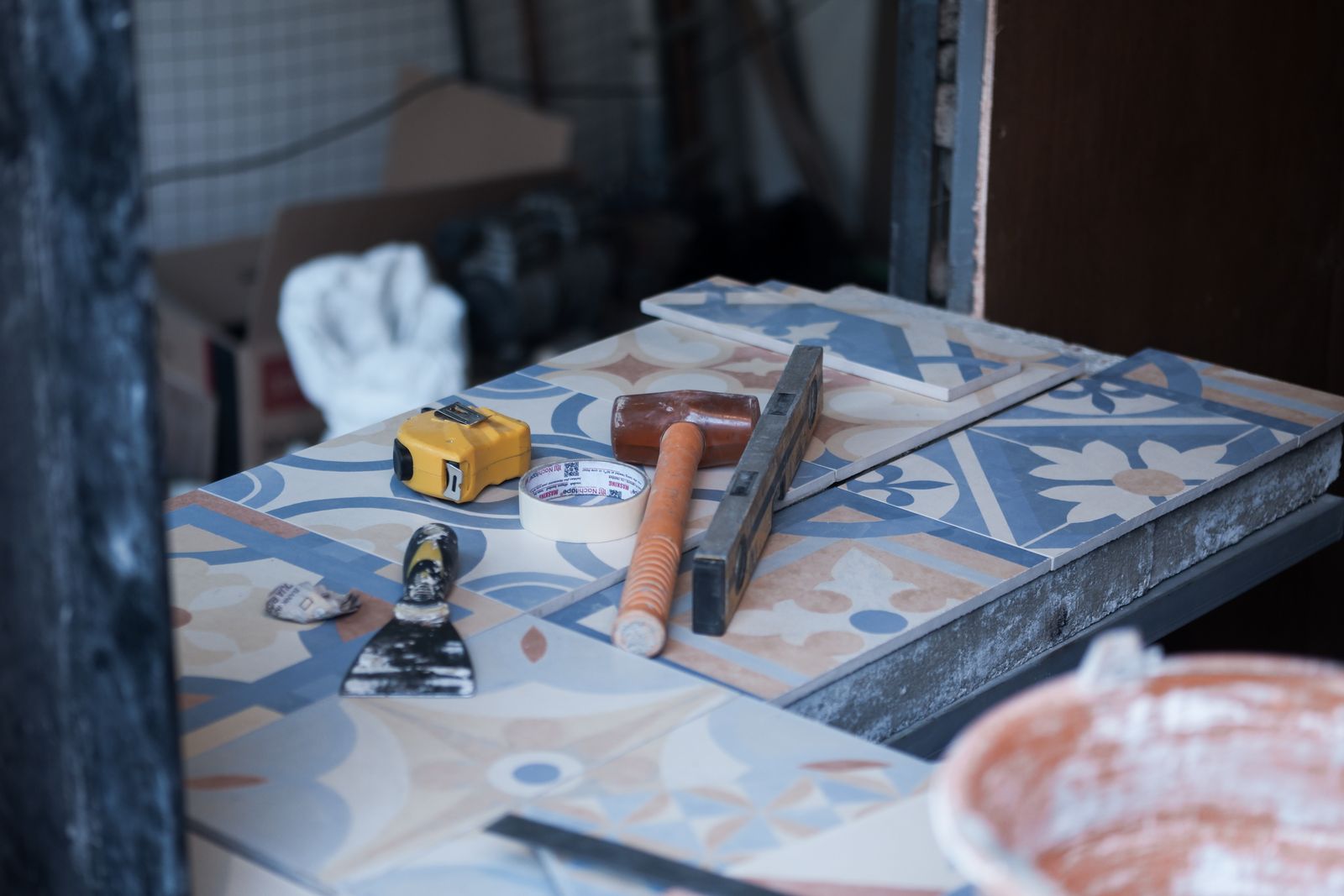A tile setter working on a bathroom wall with a notched trowel